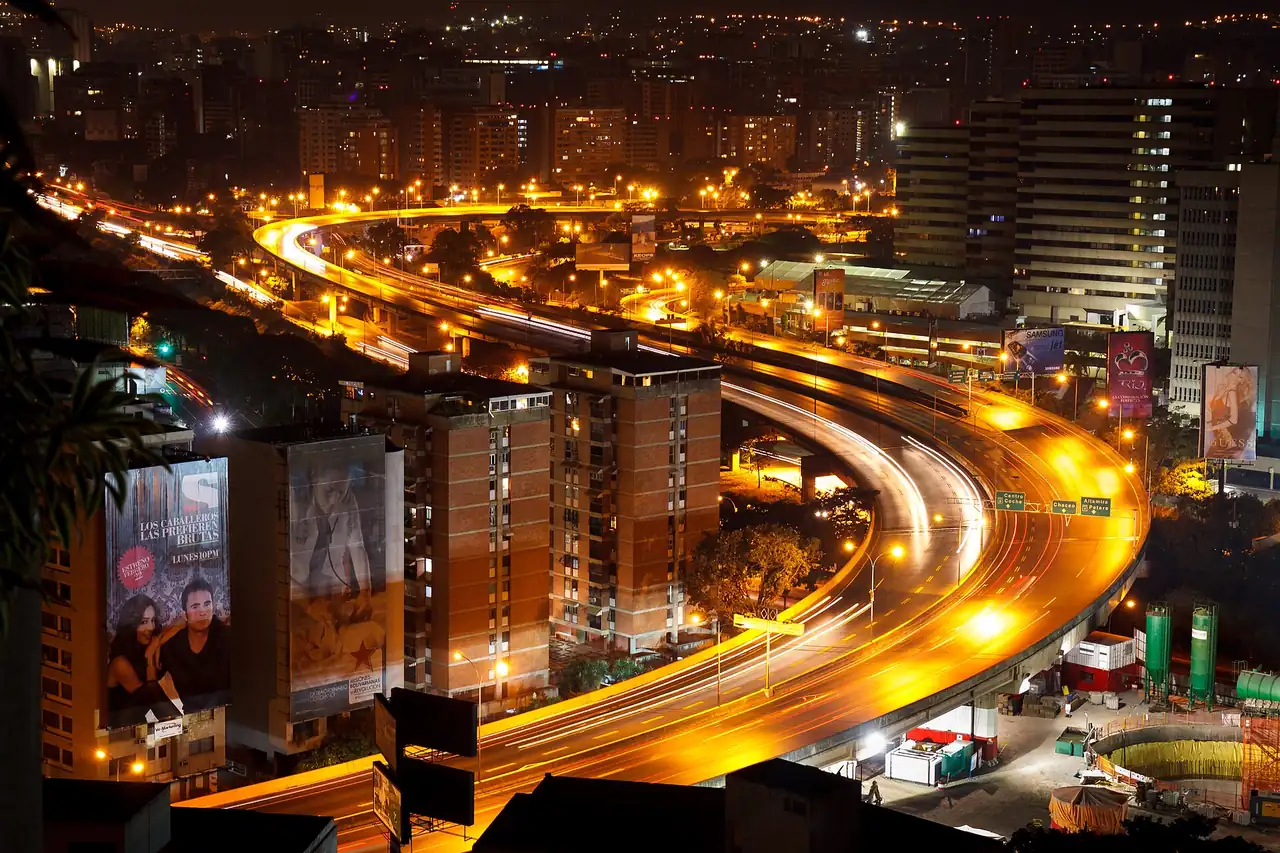 Una autopista de Caracas de noche, con las luces de los carros.